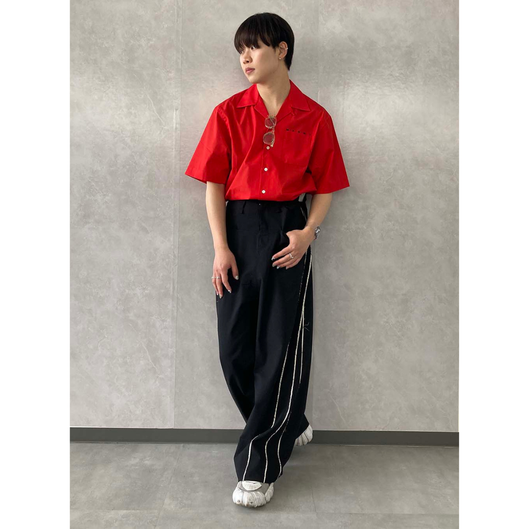 赤シャツに黒のワイドパンツを合わせた20代におすすめの最低気温25度のメンズの服装