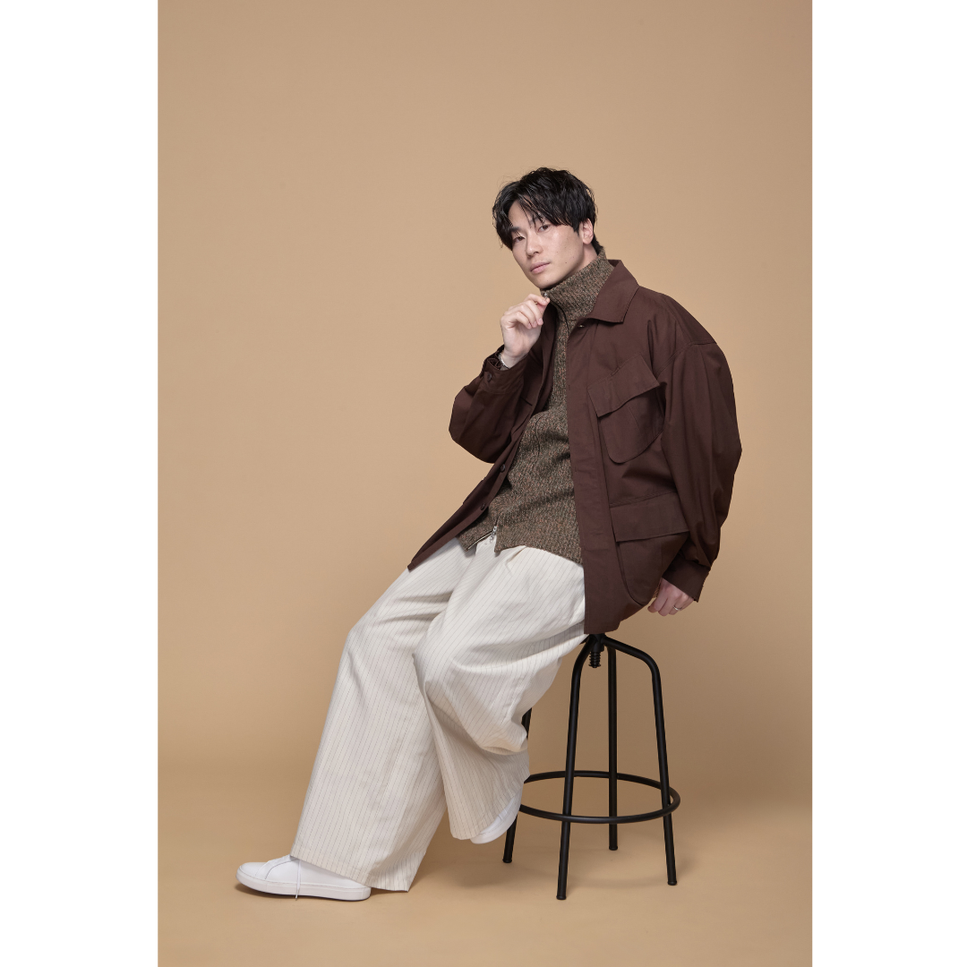 ブラウンのファティーグジャケットにアイボリーのボトムスを合わせたミリタリースタイル
