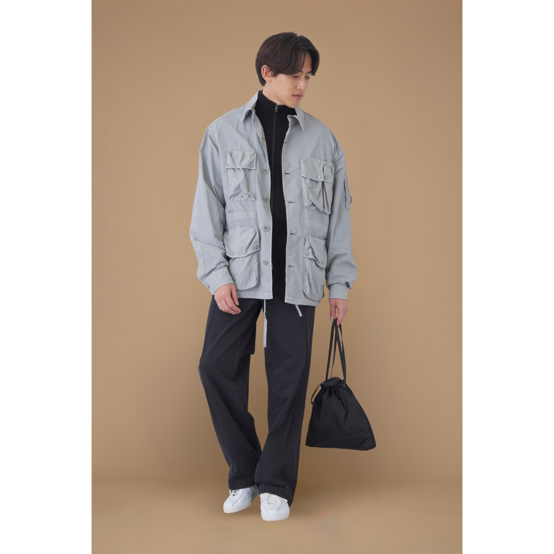 グレーのミリタリーシャツジャケットにブラックボトムスを合わせたミリタリースタイル